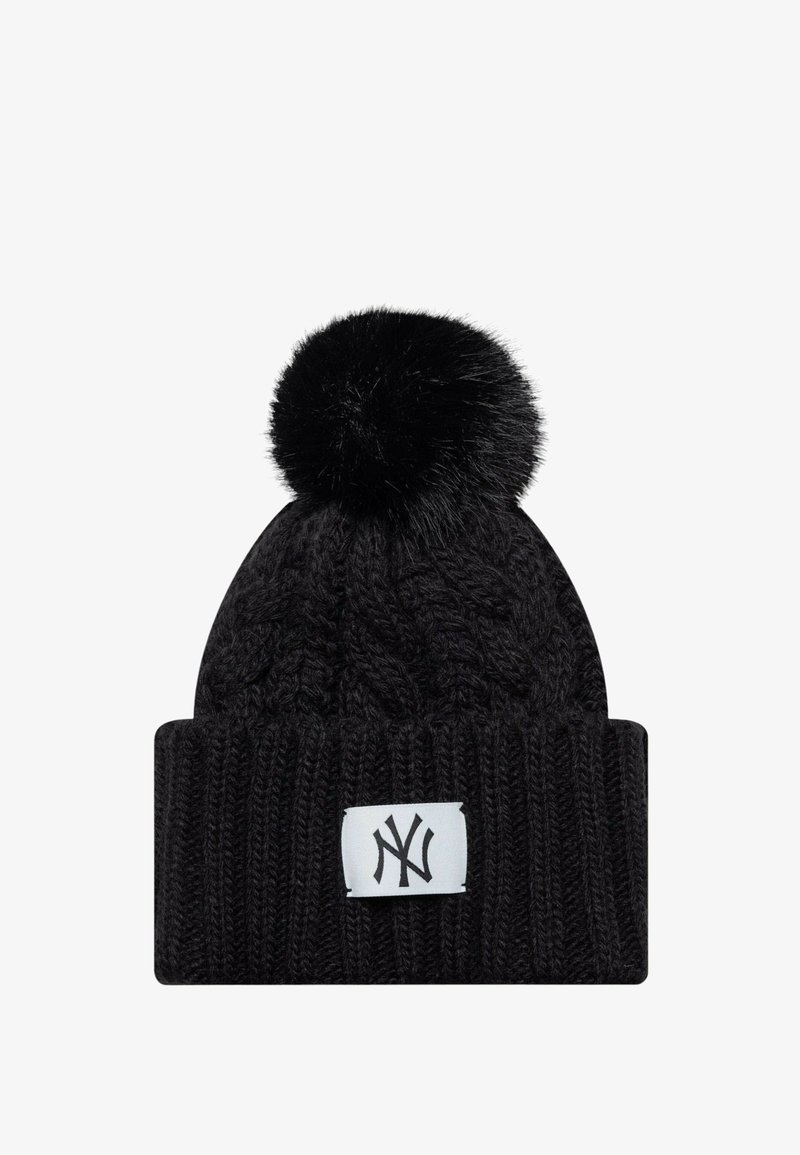 Bonnet d'hiver noir en maille avec gros pompon sur le dessus et écusson blanc présentant le logo entrelacé "NY" en noir sur le revers.