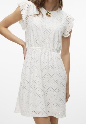 Valkoinen silmäreikäpitsinen lyhyt mekko, jossa liehuvat hihat ja vyötärö kiristettynä, yhdistetty siniseen nauhaan ripustettuun kultaseppele-kaulakoruun.