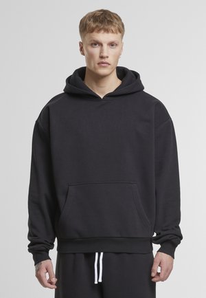 Sweatshirt à capuche noir en tissu doux, doté d'une poche kangourou, de poignets côtelés et d'un ourlet élastiqué. Texture lisse.