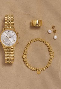 Orologio in tonalità oro con cinturino in metallo, quadrante bianco e numeri romani. Include un anello oro, un bracciale di perline e orecchini a goccia in perle.