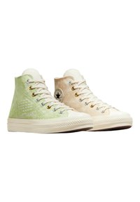 Sneakers înalte de culoare verde și bej deschis, cu material texturat, șirete albe, gauri pentru șireturi de bronz și talpă din cauciuc care prezintă un capac pentru degetul mare texturat.