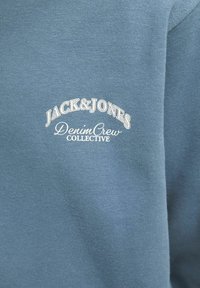 Felpa blu in cotone con collo rotondo, caratterizzata da testo bianco: "JACK & JONES DenimCrew COLLECTIVE" in una forma curva sul davanti.