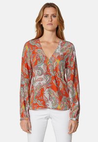 Langärmlige Bluse in Orange mit Paisleymuster in Pink und Grün. Mit tiefem V-Ausschnitt und weichem, glattem Stoff.