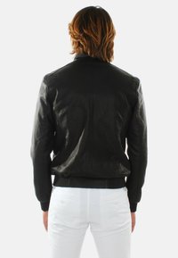 Giubbotto bomber in pelle nera con orlo e polsini a coste, caratterizzato da una texture liscia e da dettagli semplici sul retro.