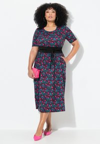 Mustapohjainen kukkakuosisessa midi-mekossa on vaaleanpunaisia ja teal-värisiä yksityiskohtia, sovitettu vyötärö mustalla vyöllä, lyhyet hihat ja sivutaskut. Yhdistetään vaaleanpunaisiin asusteisiin.