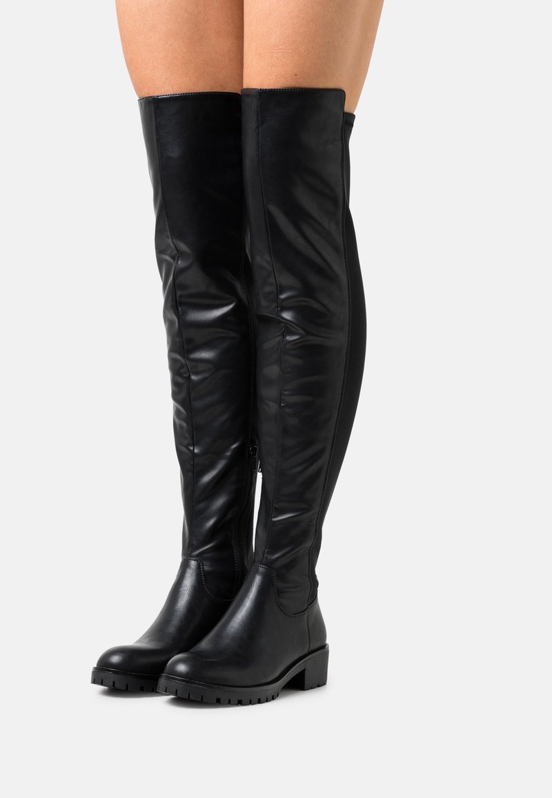 Botas negras por encima de la rodilla hechas de cuero suave, con un tacón grueso, cremallera lateral y una textura mínima con una silueta elegante.