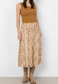 Ruskea ribatty tanktoppi yhdistettynä kuvioituun beigeen hameeseen. Hameessa on ilmava muotoilu ja kuminauhavyötärö, joka on yhdistetty ruskeisiin saappaisiin.