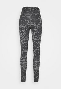 Leggings neri con un motivo camouflage in diverse sfumature di grigio. Il tessuto ha una texture liscia e un design con vita alta.