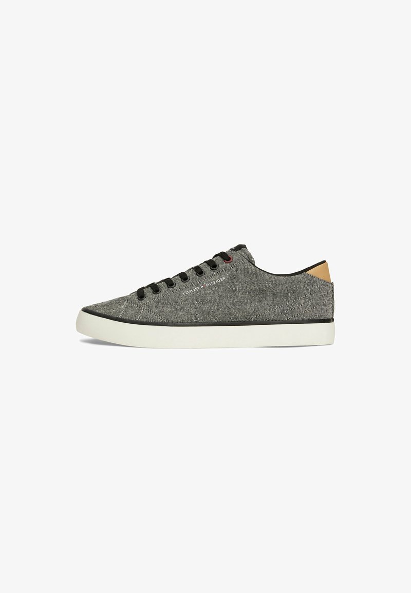 Gray canvas sneakers with black eyelets, white sole, and a tan accent at the heel. Features simple design and logo detailing on the side.