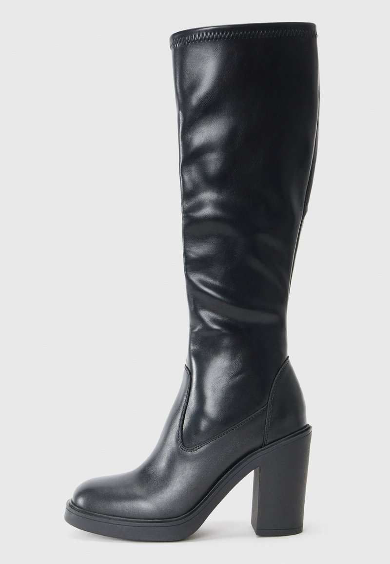 Boots negre până la genunchi, fabricate din piele netedă, cu un design elegant, vârf pătrat și toc înalt și robust pentru un plus de înălțime. Prezintă cusături minime.