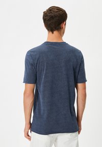 Mörkblå kortärmad T-shirt med rund halsringning, som har en mjuk textur och en avslappnad passform, visar bakview. Inga synliga mönster.