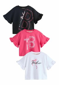 Kolme lyhythihaista T-paitaa: musta vaaleanpunaisella kuviolla, vaaleanpunainen valkoisella kukkakuviolla ja valkoinen mustalla tekstillä, joissa on röyhelöhihat.