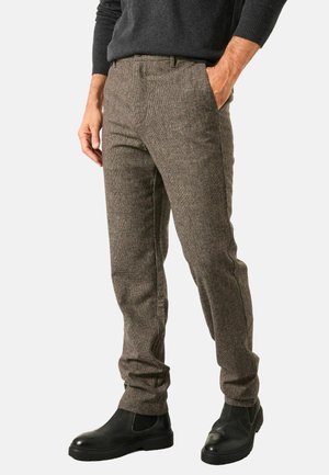 Brown houndstooth pattern trousers made from a textured fabric; slim fit; side pockets; paired with black chelsea boots.