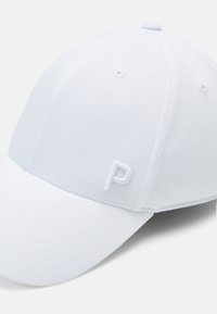 Balta beisbola cepure, izgatavota no auduma, ar izliekto maliņu un nelielu izšūtu burtu "P" priekšējā kreisajā pusē.