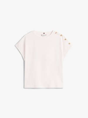 T-shirt blanc à manches courtes avec une coupe ample, ornée de détails en bouton doré sur l'épaule et d'un col rond. Texture en coton lisse.