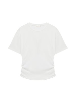 T-shirt blanc manches courtes avec col rond et léger froncé à la taille, posé à plat sur un fond blanc.