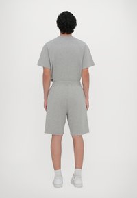 Gray cotton t-shirt and shorts set with a relaxed fit. T-shirt has short sleeves; shorts feature an elastic waistband and raw hems.