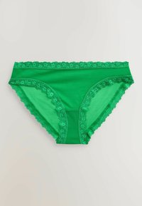 Sous-vêtement bikini vert pour femme avec bordure en dentelle fleurie le long de la taille et des ouvertures des jambes, présenté à plat sur un fond neutre.