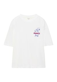 T-shirt blanc à manches courtes avec un petit graphisme de Snoopy et Woodstock au-dessus du texte rouge et bleu "Peanuts Social Club" sur la poitrine.