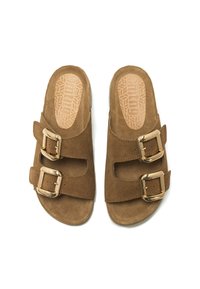 Sandali in suede marrone con due ampie cinghie e fibbie dorate, suole piatte e plantari testurizzati con un motivo geometrico.