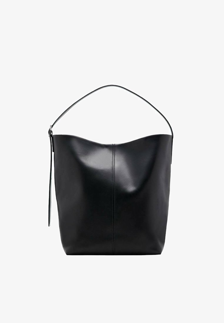 Bolso tote de cuero negro con un borde superior curvado, una correa de hombro única y textura suave. Presenta un sutil detalle de costura en la parte frontal.