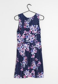 Mouwloze jurk met bloemenpatroon in marineblauwe kant, versierd met paarse, roze en witte accenten; heeft een geplooide rok en een ronde halslijn.