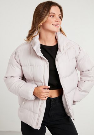 Light pink puffer jacket with a high collar, zip closure, elastic cuffs, and side pockets. Smooth texture and quilted pattern.