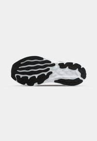 Zwart-witte sneakerzool met een golvenpatroon, getextureerd rubber voor grip en flexibele groeven voor beweging.