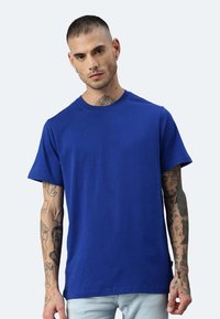 T-shirt di cotone blu con scollatura rotonda e maniche corte. Il tessuto appare liscio e presenta una vestibilità comoda.