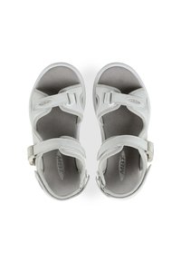 Sandalias blancas con un diseño tipo zapatilla, correas ajustables, suela texturizada y un contrafuerte acolchado para mayor comodidad.