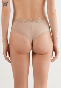 Beige high-waisted lingerie van gestreepte stof met kantafwerking. Soepele textuur met een decoratieve rand, die snugger aansluit rond de taille en heupen.