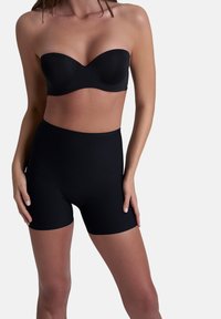 Zwarte strapless bh en high-waisted shorts van glad, rekbaar materiaal. De shorts hebben een naadloze afwerking rond de taille en benen.