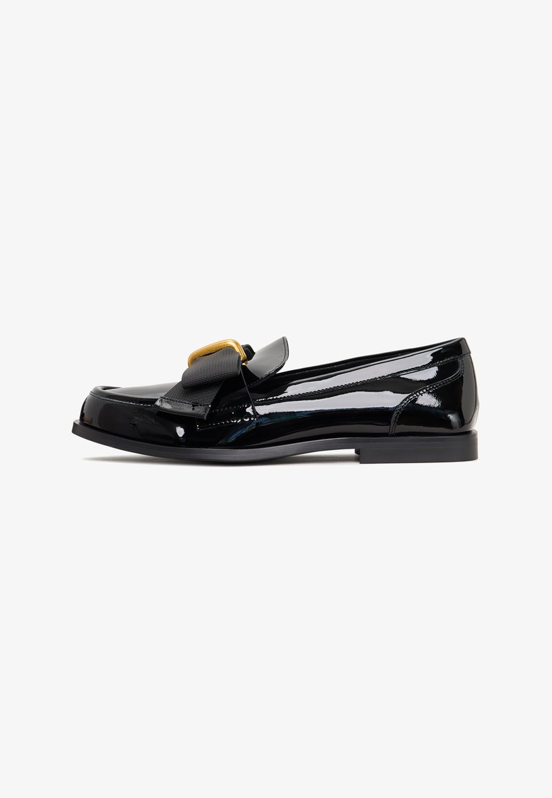 Loafers din piele patent neagră, cu un finisaj neted, călcâi ușor și un accent metalic auriu proeminent pe partea din față a curelei.