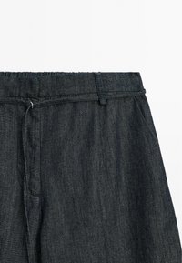 Donkerdenim broek met een relaxte pasvorm, voorzien van een elastische tailleband, zijzakken en subtiele stikseldetails.