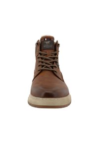 Bruine leren enkelboot met een ronde neus, gestructureerd oppervlak, beige zool en contrasterende veters, met een logo op de tong.