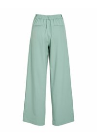 Vide bukser i et mykt mintgrønt stoff. Har elastisk midjebånd og to baklommer. Jevn tekstur, rene sømmer.