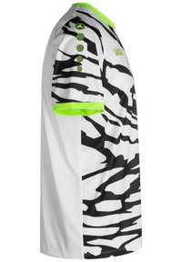 Biała koszulka sportowa w czarne paski zebry, z zielonymi akcentami na kołnierzyku i rękawach, z trzema dekoracyjnymi guzikami na ramieniu.