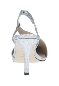 Sandale à talon haut en argent pailleté avec orteils ouverts et bride de cheville. Présente un talon étroit et une semelle lisse de couleur claire.