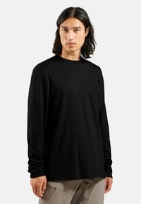 Schwarzes Langarm-T-Shirt aus leichtem Stoff, mit Rundhalsausschnitt und kleiner Brusttasche mit prägnantem Logodesign.