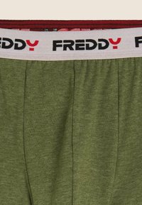 Boxer in cotone verde oliva con vita elastica caratterizzata da una fascia bianca con la scritta "FREDDY" in nero e rosso. Tessuto texturizzato.