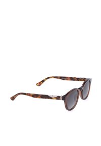 Lunettes de soleil à motif écaille avec verres ronds foncés et détail de logo argenté sur les branches, vues de profil sur fond blanc.