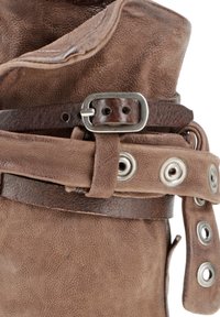 Bota de cuero marrón con un acabado texturizado, que presenta un cinturón marrón oscuro y detalles metálicos con ojales en el lateral.