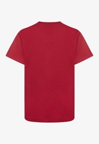 Czerwona bawełniana koszulka z klasycznym okrągłym dekoltem, krótkimi rękawami i prostym dołem. Gładka tekstura, bez widocznych wzorów ani akcentów.