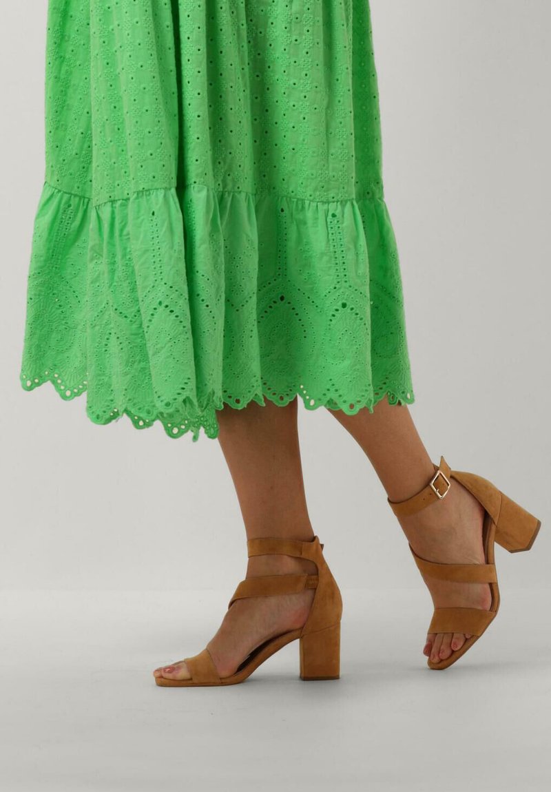Groene katoen jurk met oogjes en een scalloped zoom, gecombineerd met bruine suède sandalen met blokhak, voorzien van enkelbandjes en gesps accents.