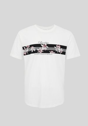 T-shirt blanc à manches courtes avec des rayures horizontales noires, ornée de fleurs roses et blanches ainsi que du texte "Brooklyn" avec des coordonnées géographiques.
