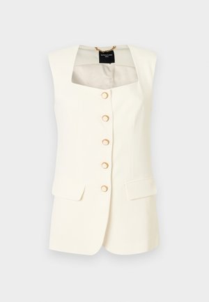 Αμάνικο σακάκι εκρού με τετράγωνη λαιμόκοψη, πέντε χρυσά κουμπιά στο μπροστινό μέρος και δύο τσέπες με καπάκι στη μέση.