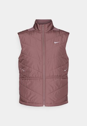 Odebljani prsluk bez rukava u boji mauve s visokim ovratnikom, zatvaranjem na patentni zatvarač i prošivenim uzorkom u obliku ševrona. Ima male reflektirajuće detalje i logo.