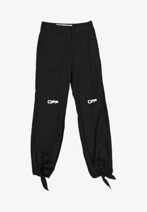 Pantalon noir avec "OFF" imprimé en blanc sur chaque cuisse, resserré et noué aux chevilles avec des lanières en tissu.