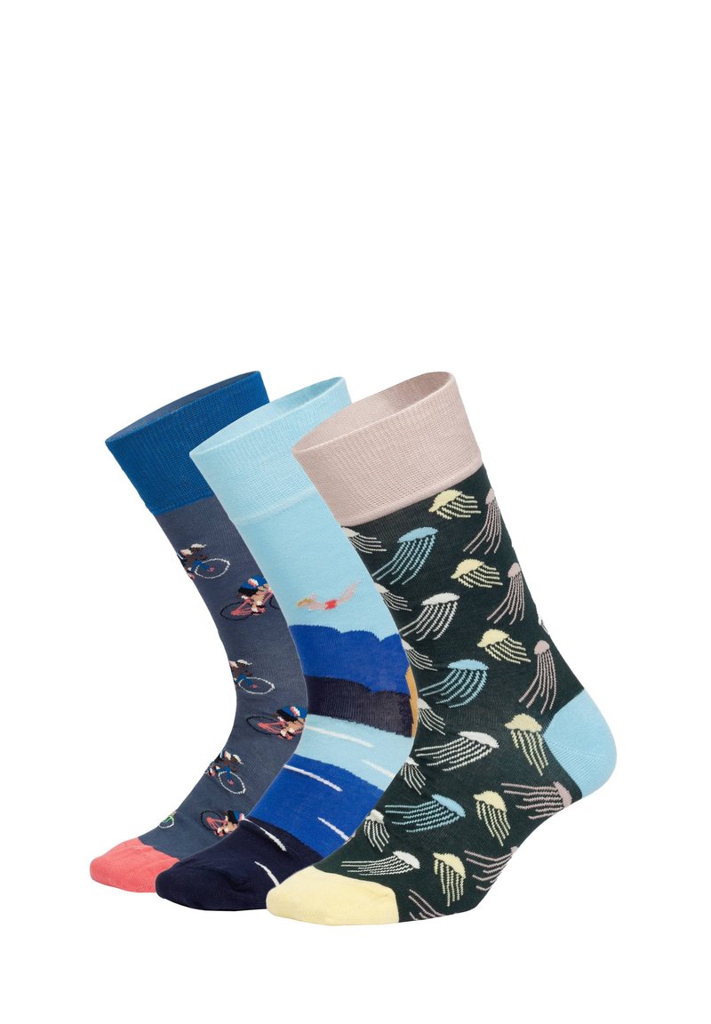 Tři barevné ponožky se vzory: cyklisté na tmavě modré, plavci a vlny na světle modré a vícebarevné medúzy na tmavě zelené.