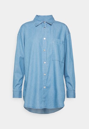 Lyseblå denimskjorte med lange ærmer, sølvfarvede trykknapper og en enkelt brystlomme, med klassisk krave og buet kant.